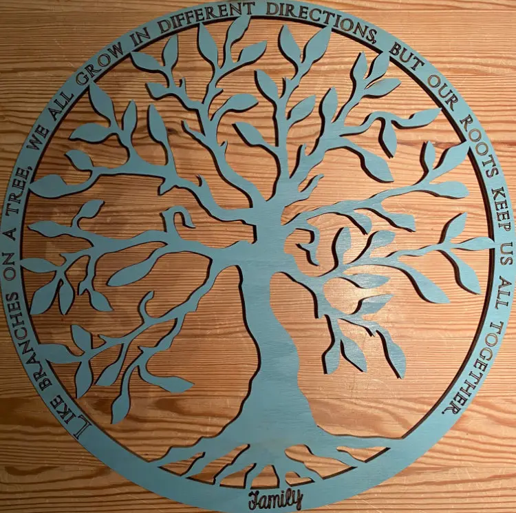 Lebensbaum aus türkis bemaltem Holz im Kreis mit Spruch über die gemeinsamen Wurzeln einer Familie